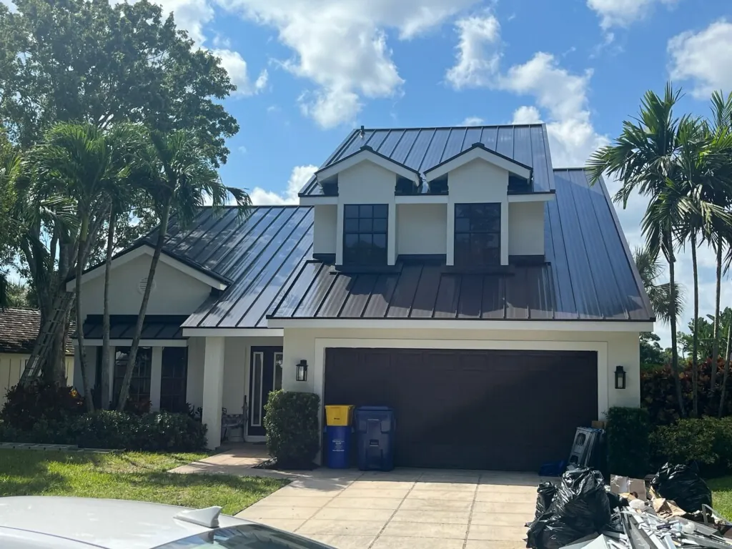 Two-story Florida home with a completed dark gray standing-seam metal roof
