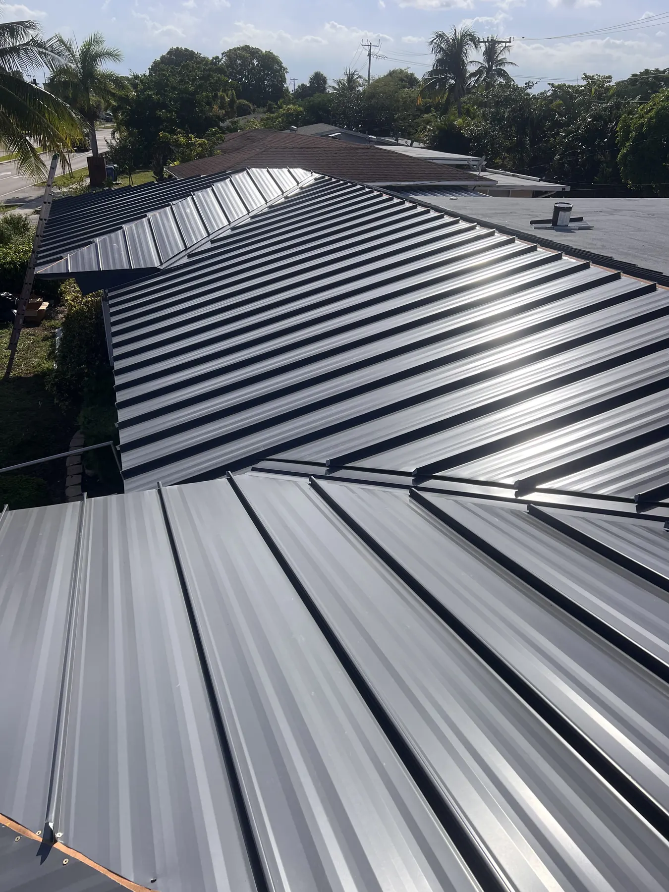 Close view of dark standing-seam panels meeting across a valley