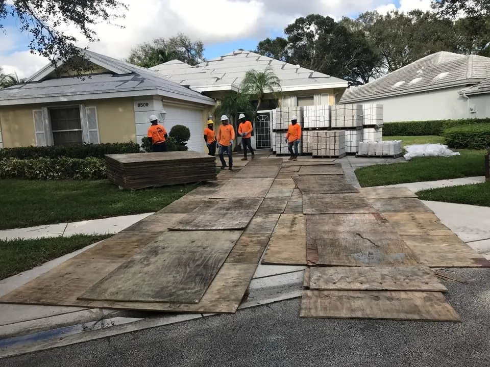M&M roofing crew and materials staged on driveway protection