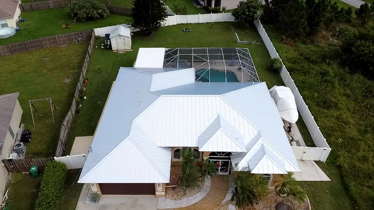 Aerial view of a white metal roof across intersecting roof sections