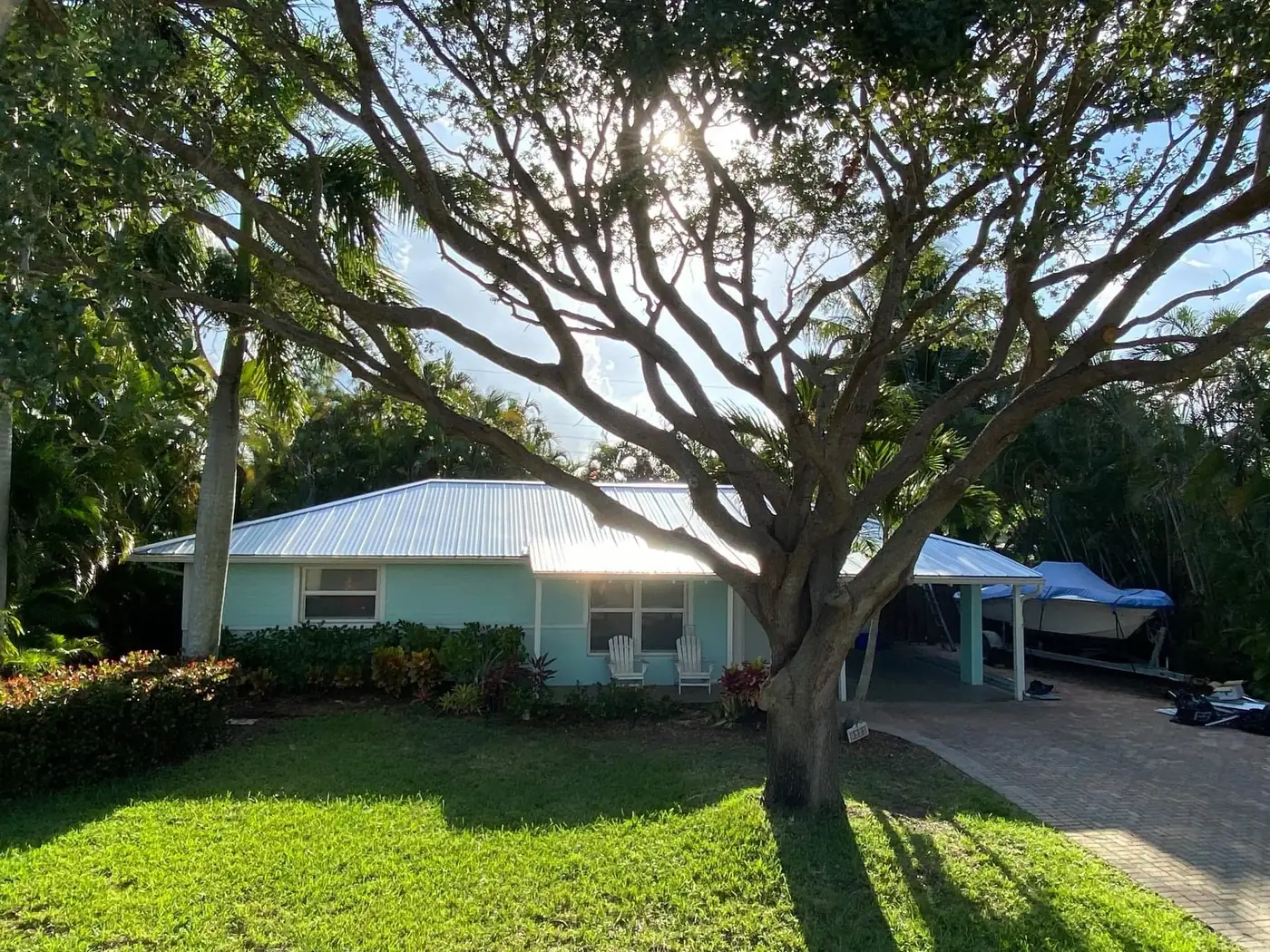 Front view of a small home with a completed white metal roof