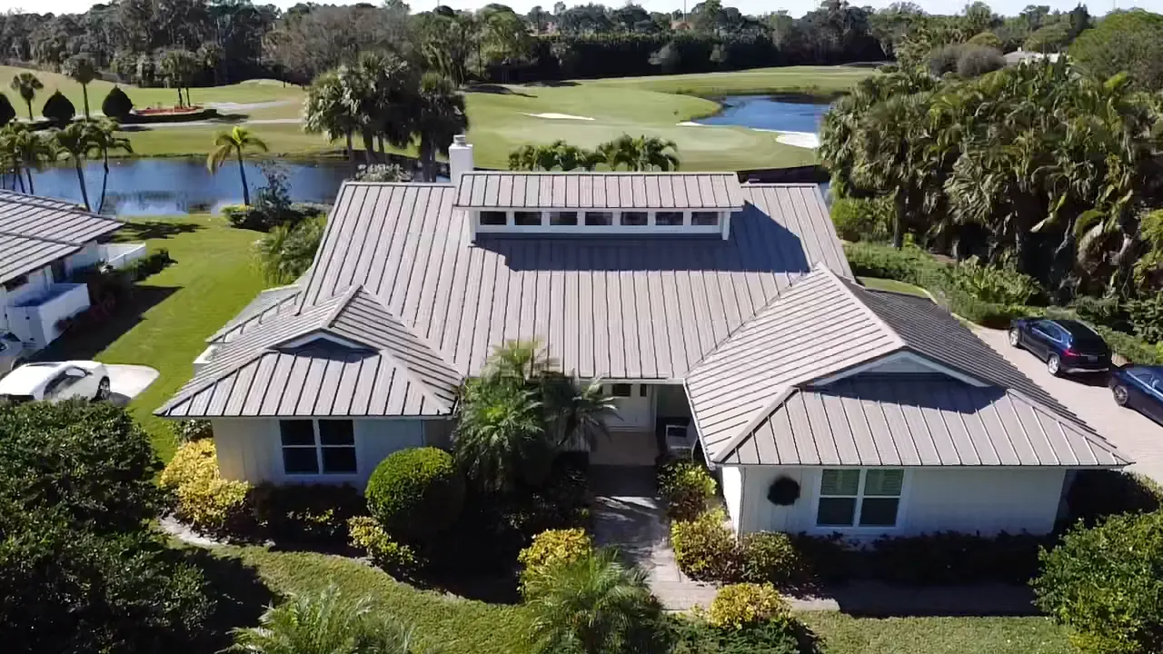 Aerial view of a white metal roof on a lakefront home