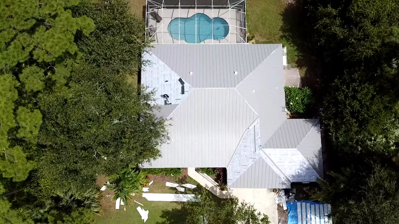 Top-down aerial view of a white metal roof with a complex hip layout