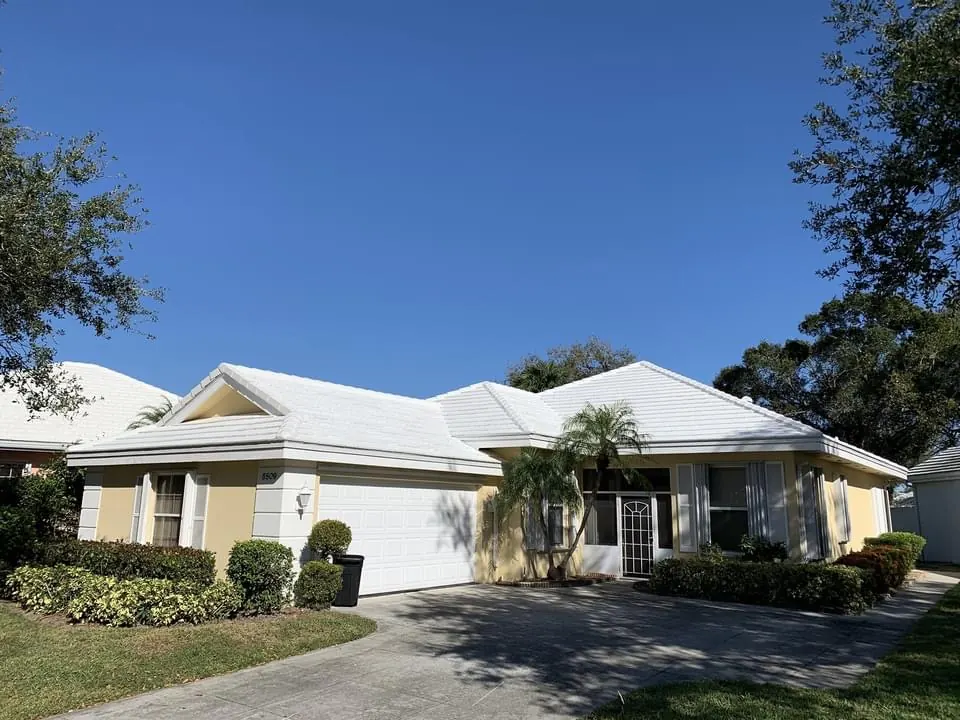 Street view of a single-story home with a completed white metal roof