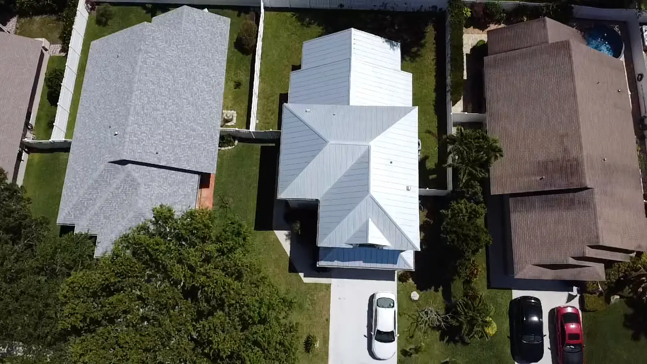 Top-down aerial view of a completed white metal roof
